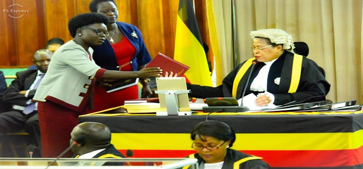 Speaker Anita Among hands over a copy of the Rules of Procedure to Hon. Eunice